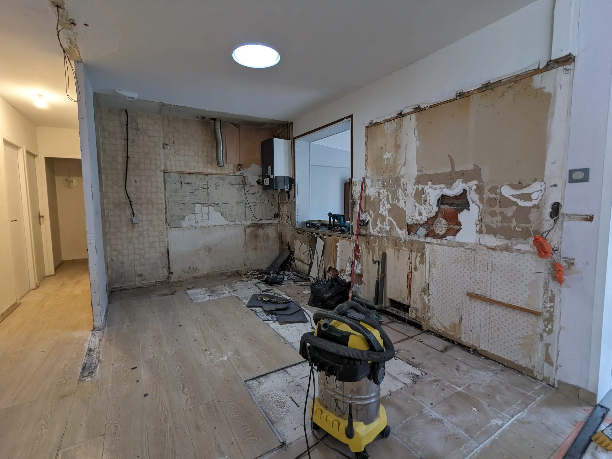 Cuisine déposée avec murs mis à nu et outillage de chantier