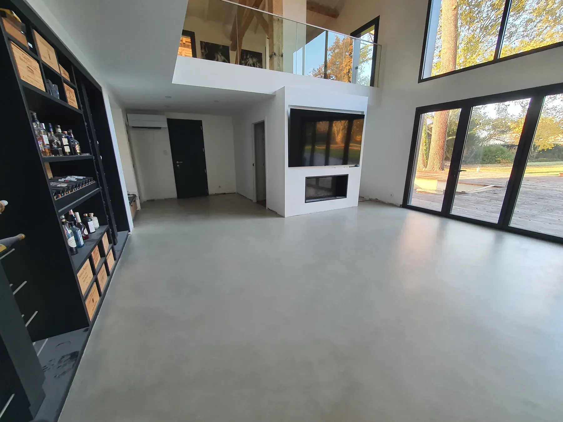 Grande pièce de vie rénovée avec mezzanine vitrée et baies noires